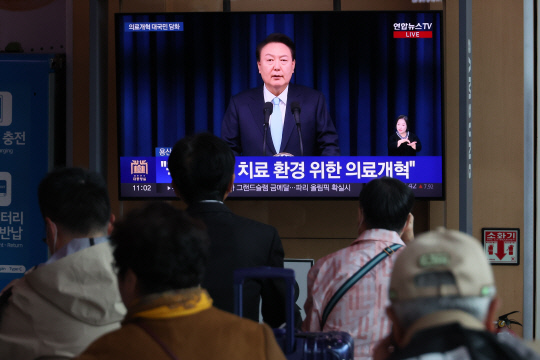 1일 오전 서울역 대합실에서 시민들이 의과대학 증원을 비롯한 의료 개혁과 관련한 윤석열 대통령의 대국민 담화를 지켜보고 있다. [연합뉴스]